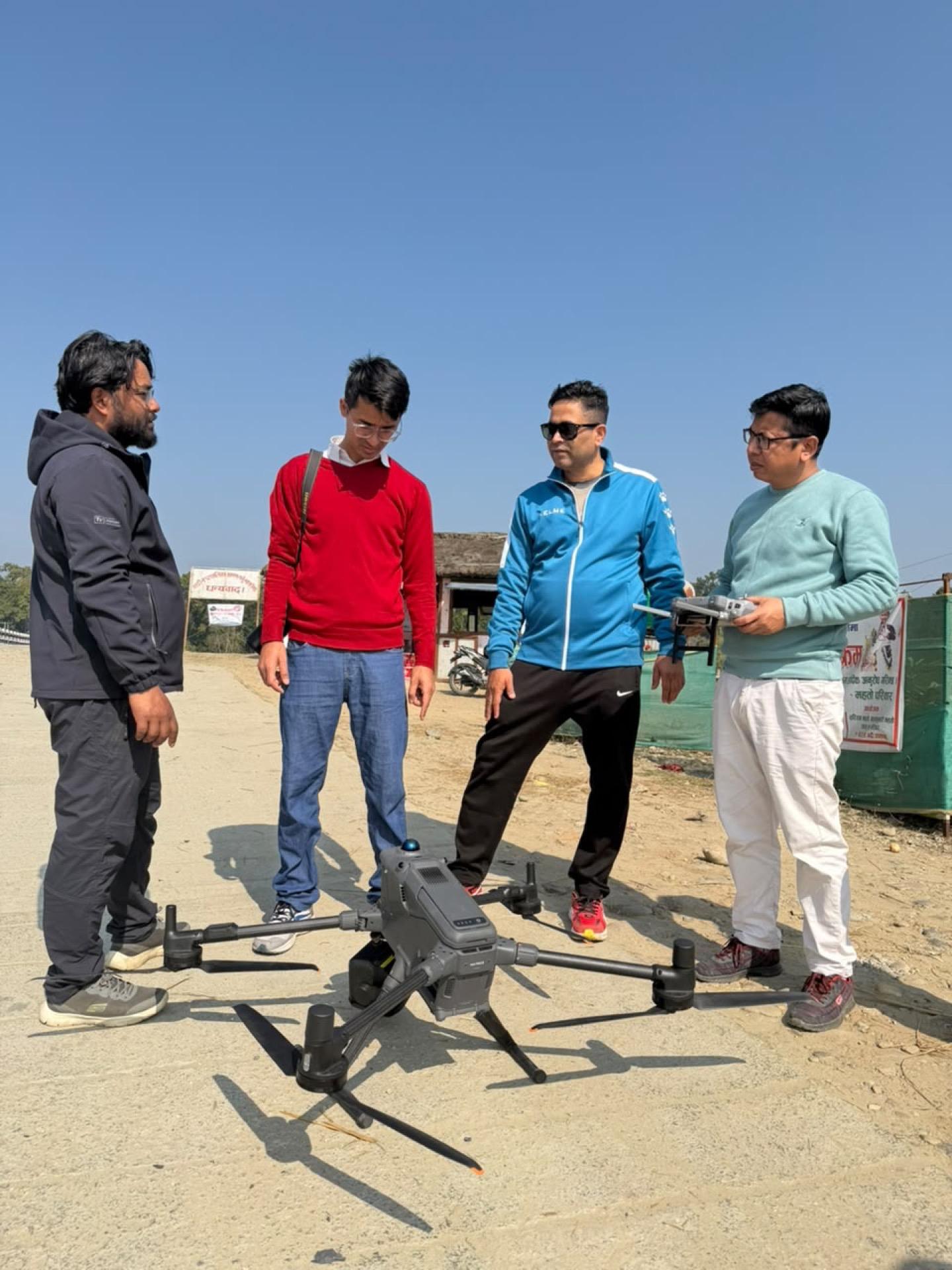Four e2services team members inspecting a survey drone before takeoff
