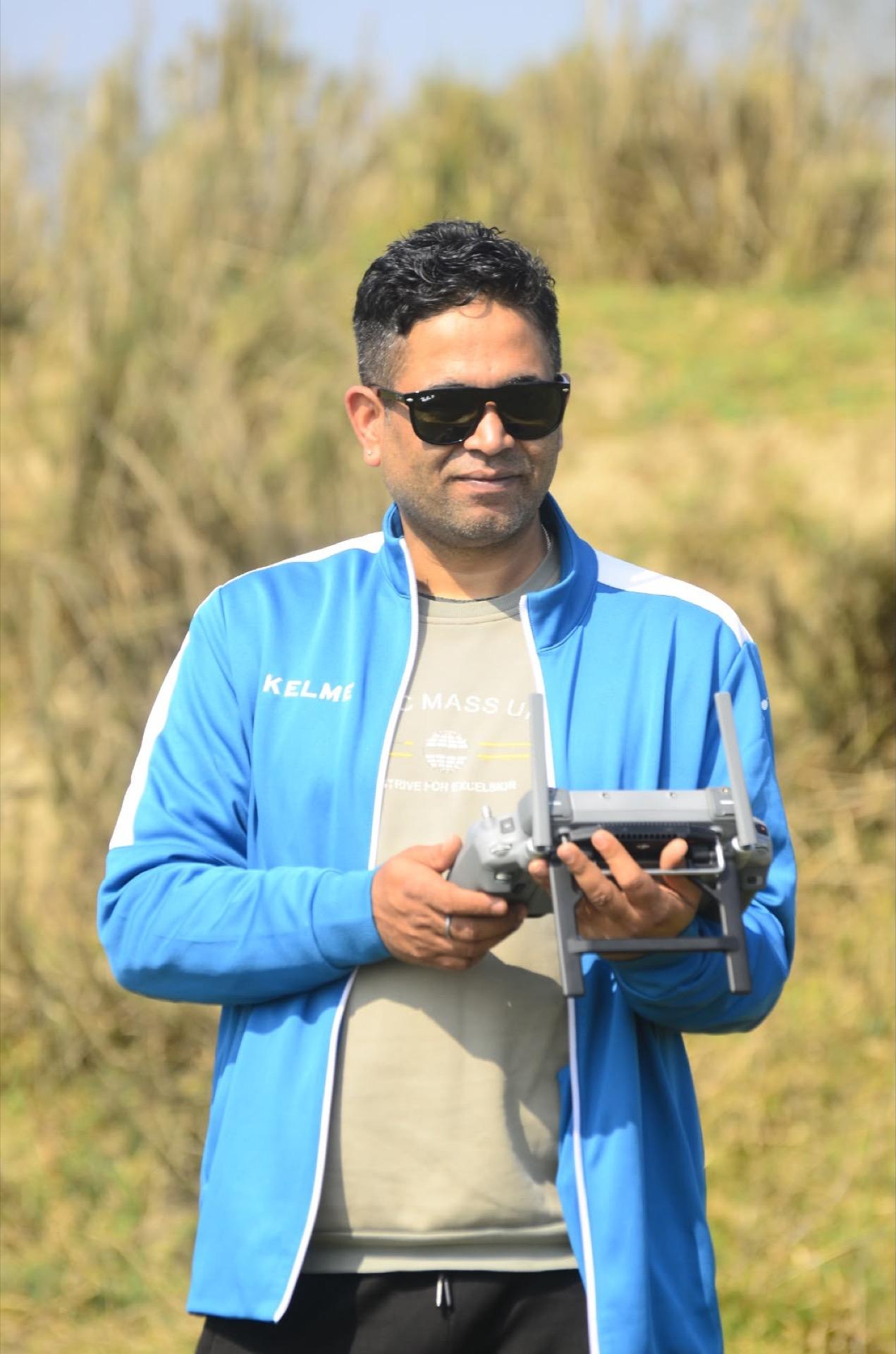 Drone operator working along a dry riverbank survey site