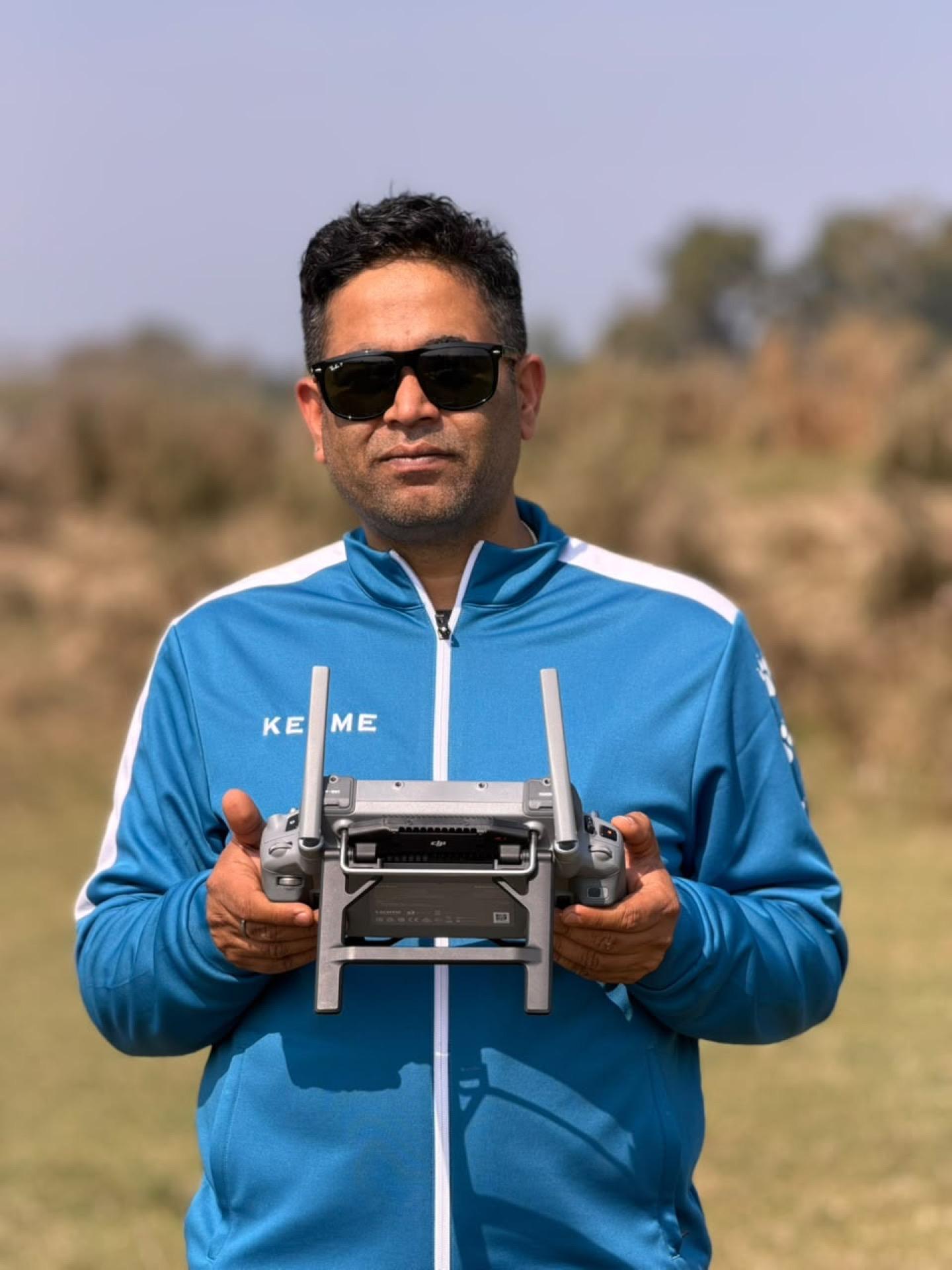 e2services drone pilot holding a flight controller during a field survey