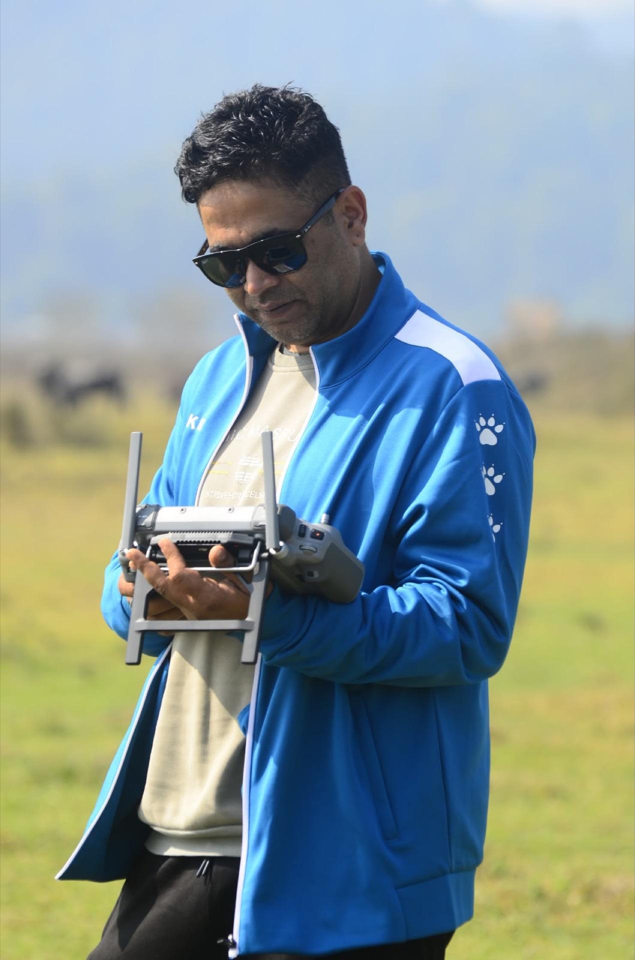 Pilot checking flight telemetry on a drone controller in pasture land